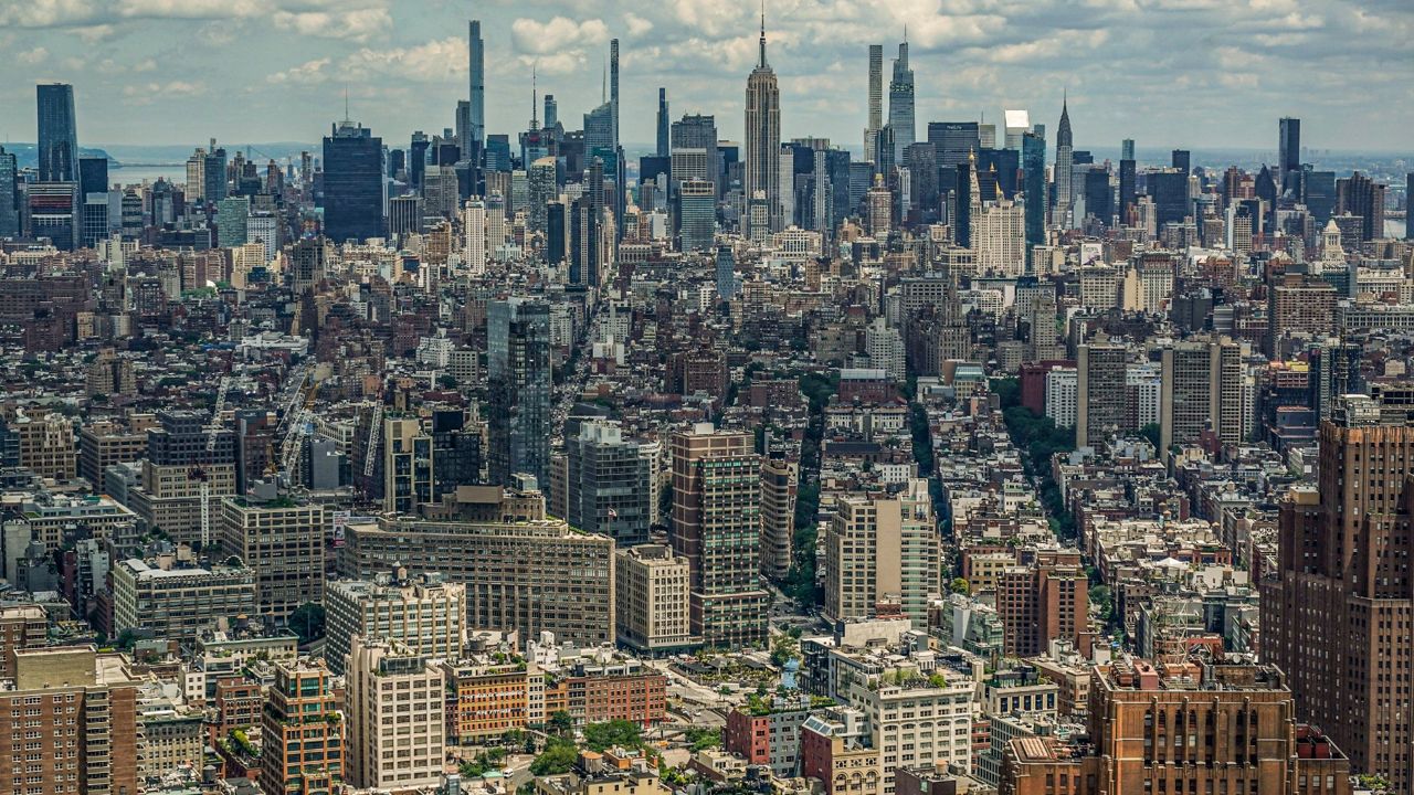 A view of the New York City skyline showing at least hundreds of building exteriors, with the Empire State Building in the center, is seen from One World Trade.