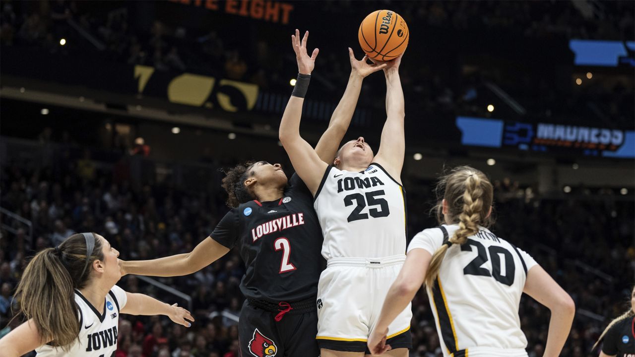 Louisville forward Nyla Harris (2) and Iowa forward Monika Czinano (25) fight for a rebound during the first half of an Elite 8 college basketball game of the NCAA Tournament, Sunday, March 26, 2023, in Seattle. (AP Photo/Stephen Brashear)