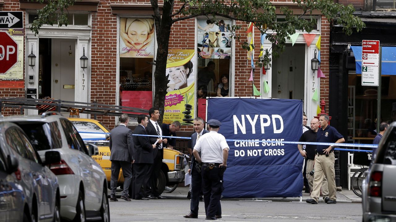 Police officers stand near a crime scene on Monday, July 28, 2014 in New York.