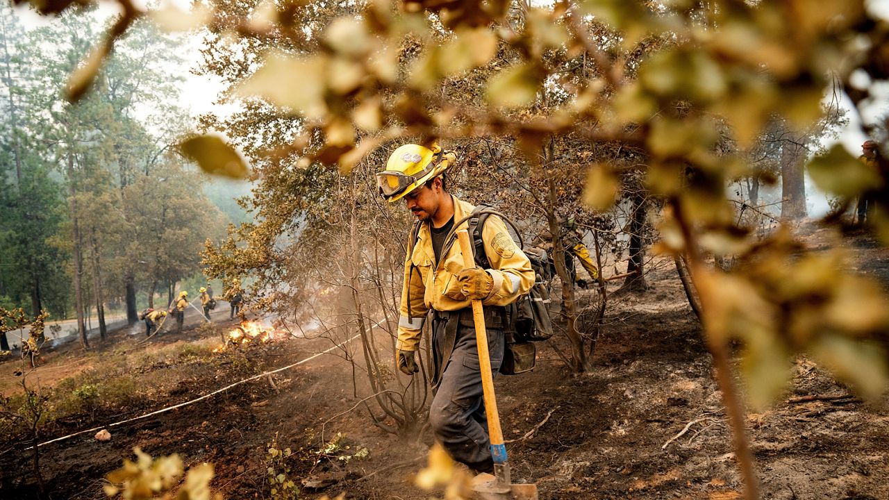 Firefighter Sergio Porras mops up hot spots while battling the Oak Fire in the Jerseydale community of Mariposa County, Calif., on Monday. (AP Photo/Noah Berger)