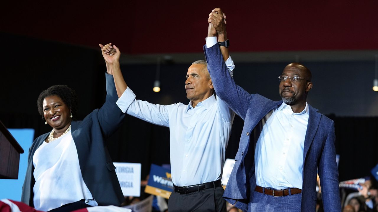 Former President Barack Obama, center, stands with Georgia gubernatorial candidate Stacey Abrams and candidate for U.S. Senate, Sen. Raphael Warnock D-Ga., during a campaign rally Friday, Oct. 28, 2022, in College Park, Ga. (AP Photo/John Bazemore)