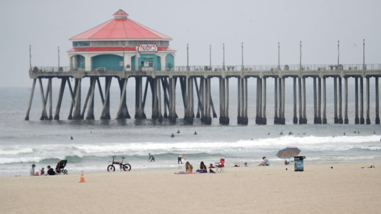 In this April 30, 2020, file photo, a lifeguard wears a mask while patrolling the beach in Huntington Beach. On Monday, Orange County health officials reported 814 new cases of COVID-19 and two more deaths, bringing the county's totals to 24,715 cases and 423 fatalities. (AP Photo/Marcio Jose Sanchez)