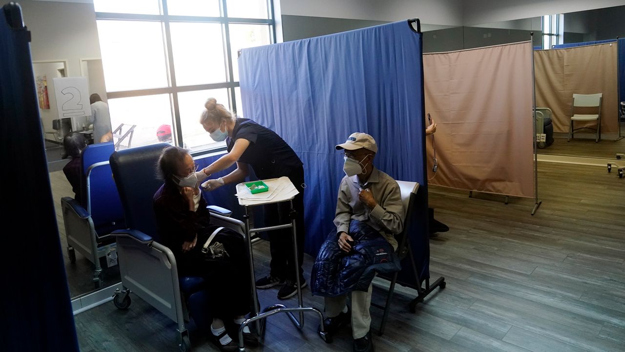 Patients receive a dose of Pfizer's COVID-19 vaccine at Families Together of Orange County Community Health Center, Feb. 26, 2021, in Tustin, Calif. (AP Photo/Marcio Jose Sanchez)