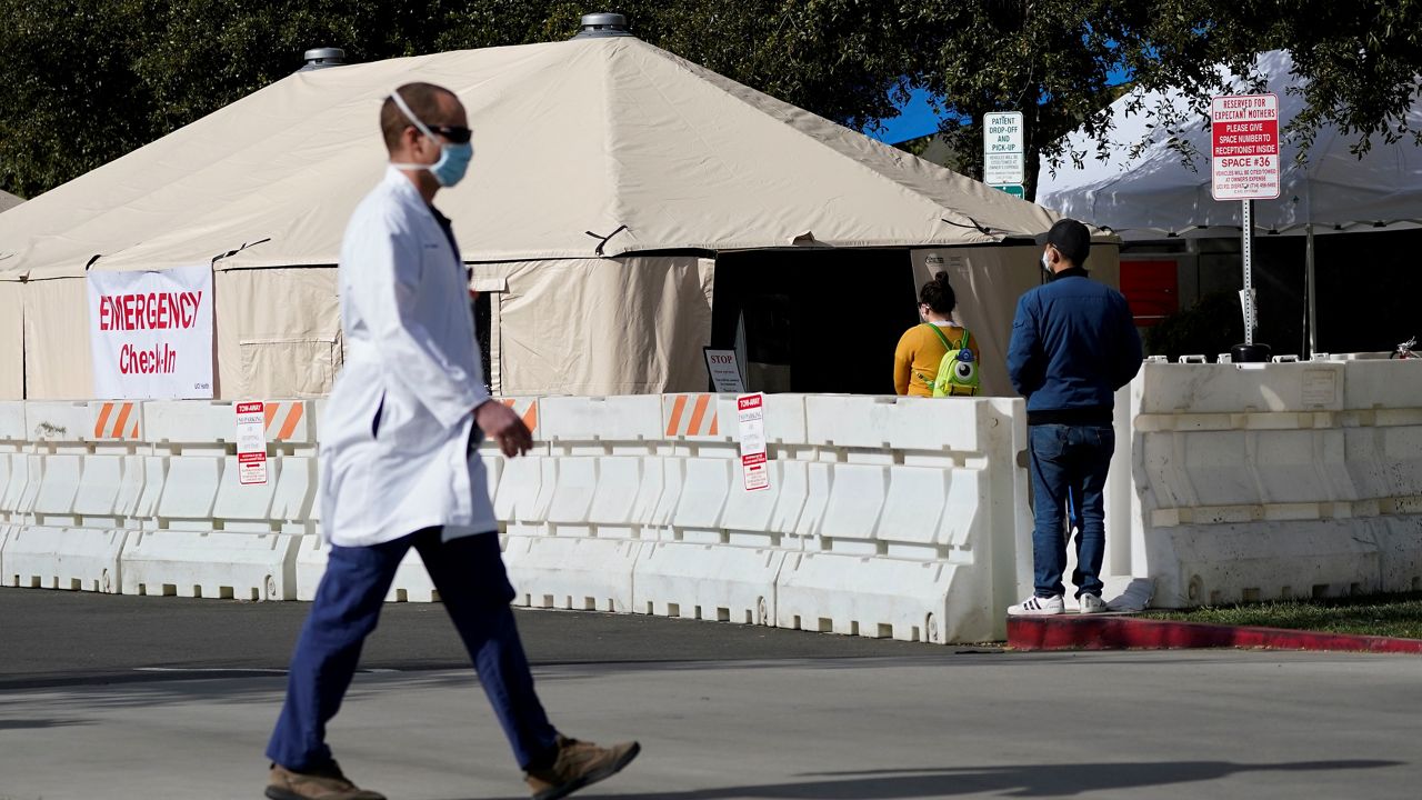 In this Dec. 17, 2020, file photo, a medical worker passes a medical tent outside the emergency room at UCI Medical Center in Irvine, Calif. (AP Photo/Ashley Landis, File)