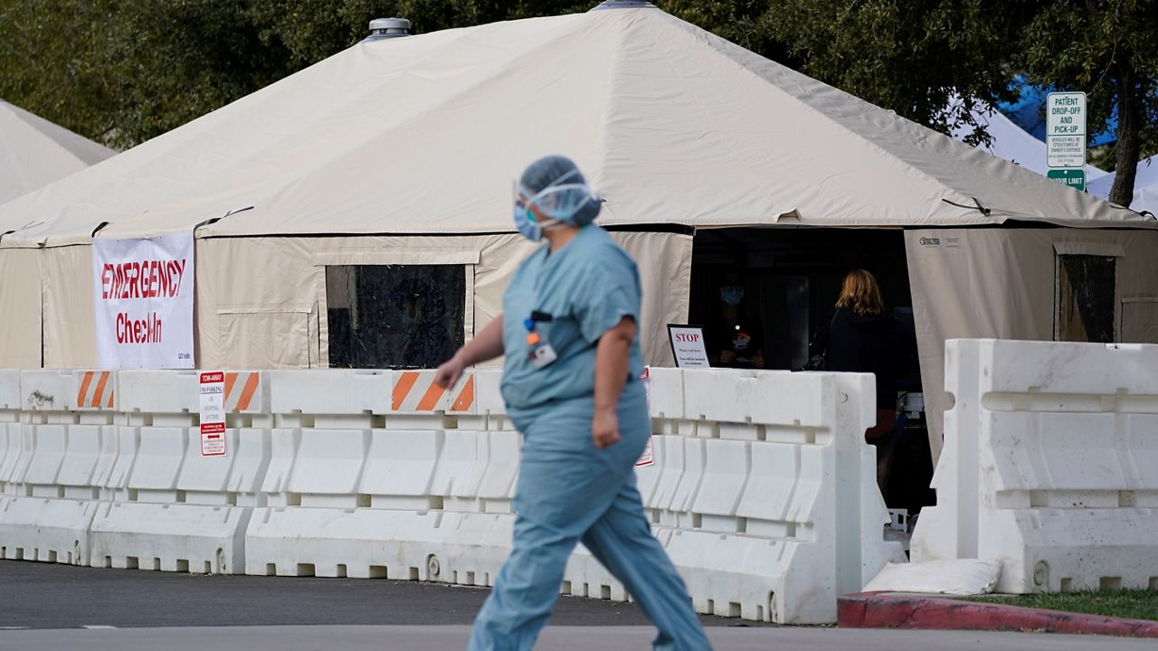 A medical worker passes a medical tent outside the emergency room at UCI Medical Center Thursday, Dec 17, 2020, in Irvine, Calif.