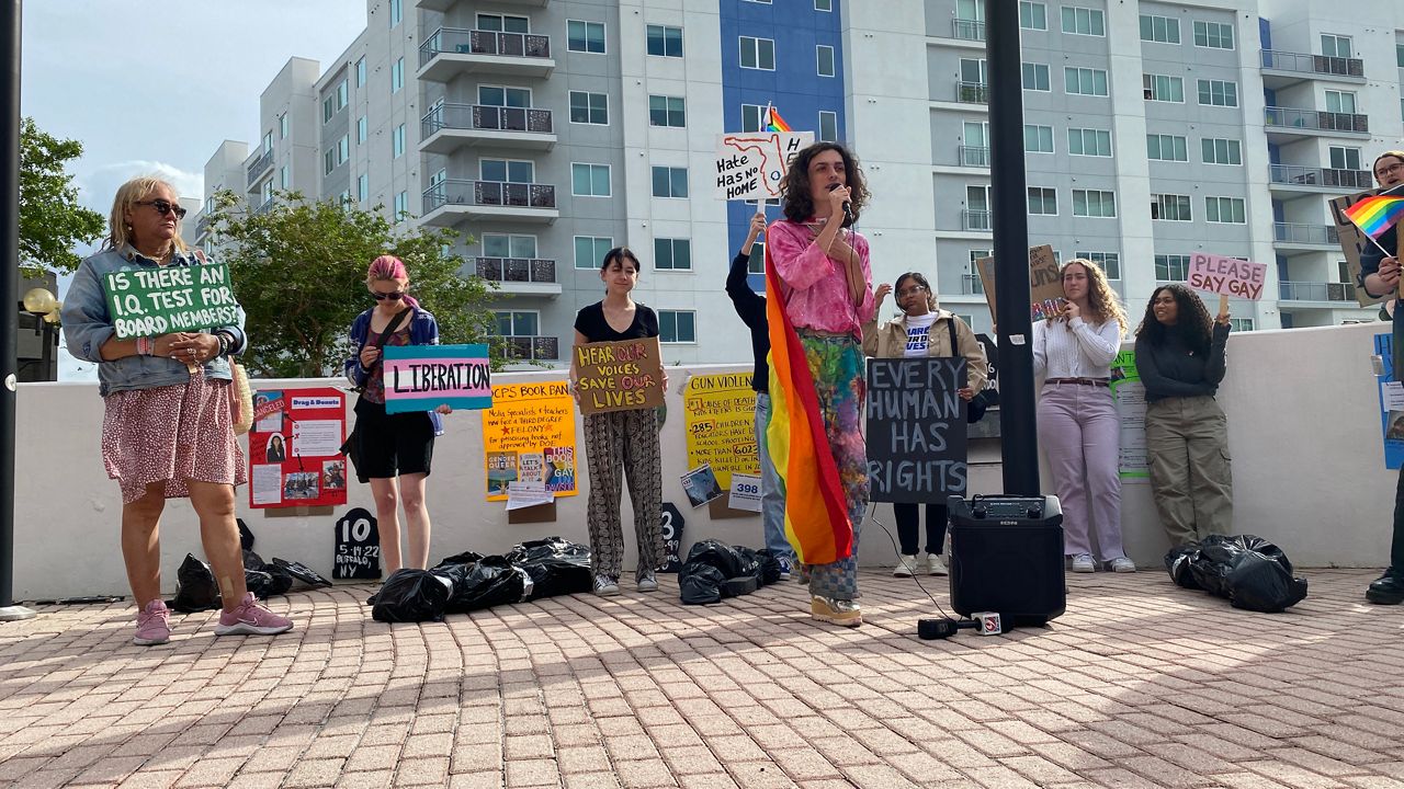 High school student Will Larkins addresses a crowd of LGBTQ+ rights advocates outside the Orange County School District building on April 11, 2023.