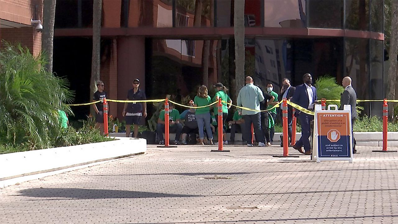 Parents line up hours ahead of Tuesday's OCPS School Board meeting to talk about the district's soon-to-expire mask mandate, (Spectrum News 13/Rachael Krause)
