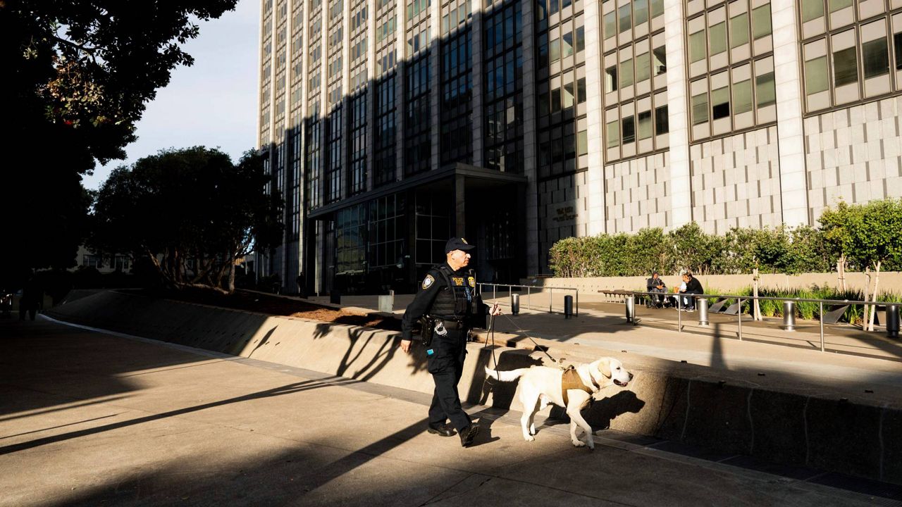 A Department of Homeland Security officer walks the perimeter of the Phillip Burton Federal Building and U.S. Courthouse where the federal trial of David DePape is underway in San Francisco, on Monday. (AP Photo/Noah Berger)