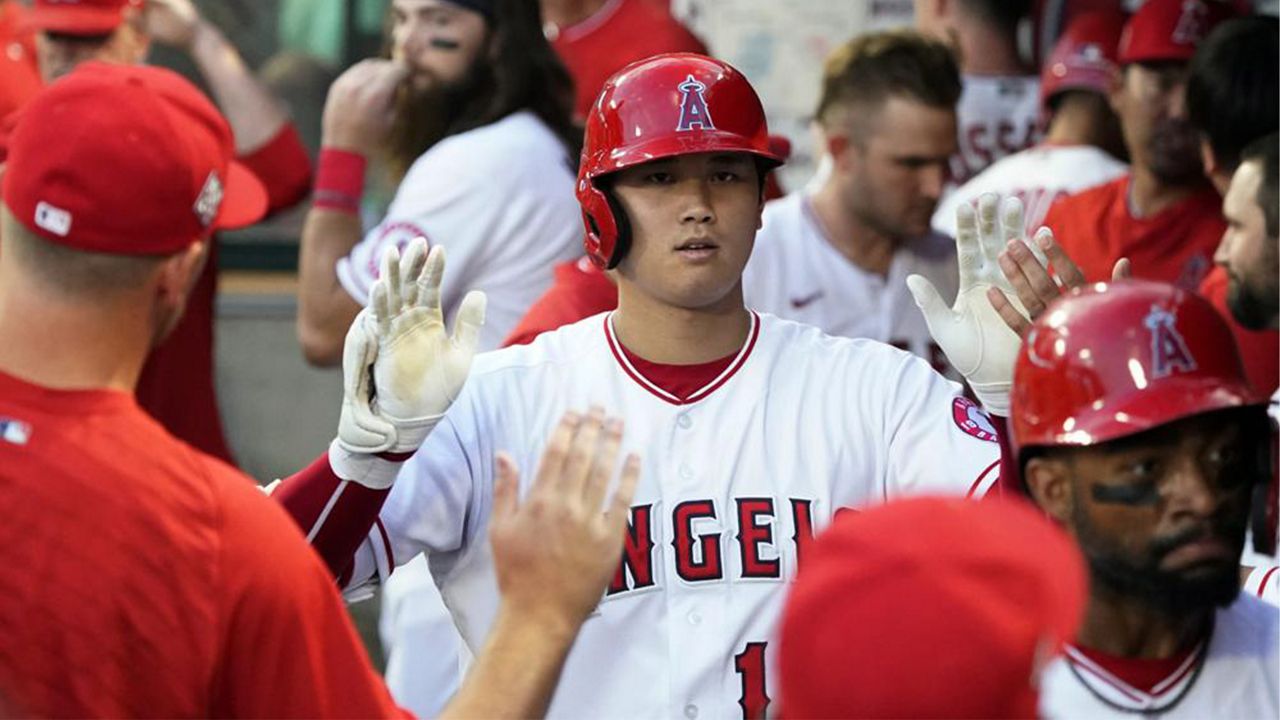 Los Angeles Angels' Shohei Ohtani celebrates his two-run home run with teammates in the dugout during the third inning of the team's baseball game against the Toronto Blue Jays on Wednesday, Aug. 11, 2021, in Anaheim, Calif. (AP Photo/Marcio Jose Sanchez)