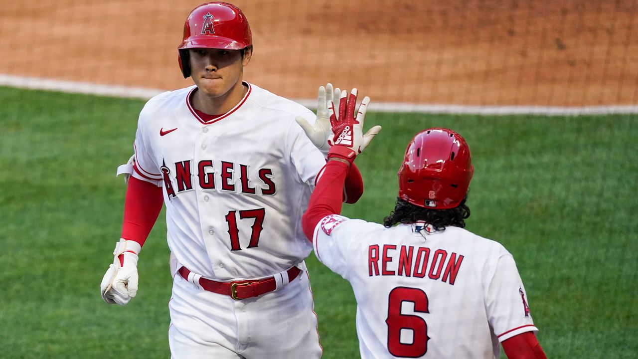 Los Angeles Angels designated hitter Shohei Ohtani (17) celebrates with Anthony Rendon (6) after hitting a home run during the first inning of a baseball game against the Cleveland Indians Tuesday, May 18, 2021, in Anaheim, Calif. (AP Photo/Ashley Landis)