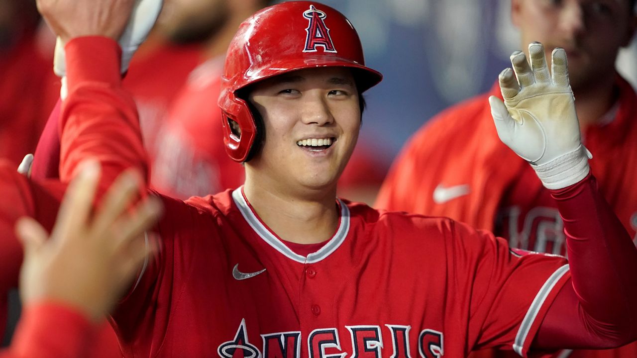 Los Angeles Angels' Shohei Ohtani is greeted in the dugout after he hit a solo home run during the first inning of a baseball game against the Seattle Mariners, Oct. 3, 2021, in Seattle. (AP Photo/Ted S. Warren, File)