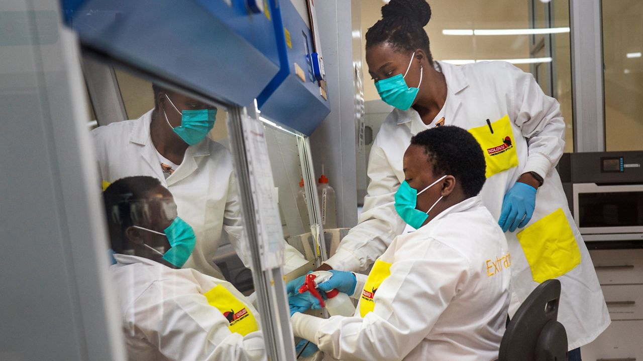 Melva Mlambo, right, and Puseletso Lesofi, both medical scientists prepare to sequence COVID-19 omicron samples at the Ndlovu Research Center in Elandsdoorn, South Africa, Dec. 8, 2021.  (AP Photo/Jerome Delay, File)