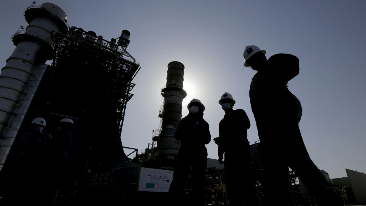 Saudi Aramco engineers walk in front of a gas turbine generator at Khurais oil field during a tour for journalists, outside of Riyadh, Saudi Arabia on June 28, 2021. (AP Photo/Amr Nabil, File)