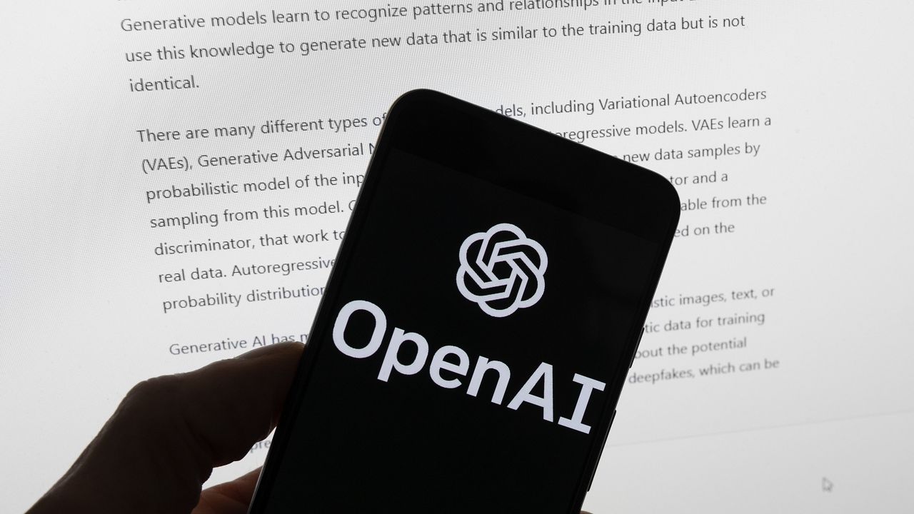 The OpenAI logo is seen on a mobile phone in front of a computer screen displaying output from ChatGPT, Tuesday, March 21, 2023, in Boston. (AP Photo/Michael Dwyer)