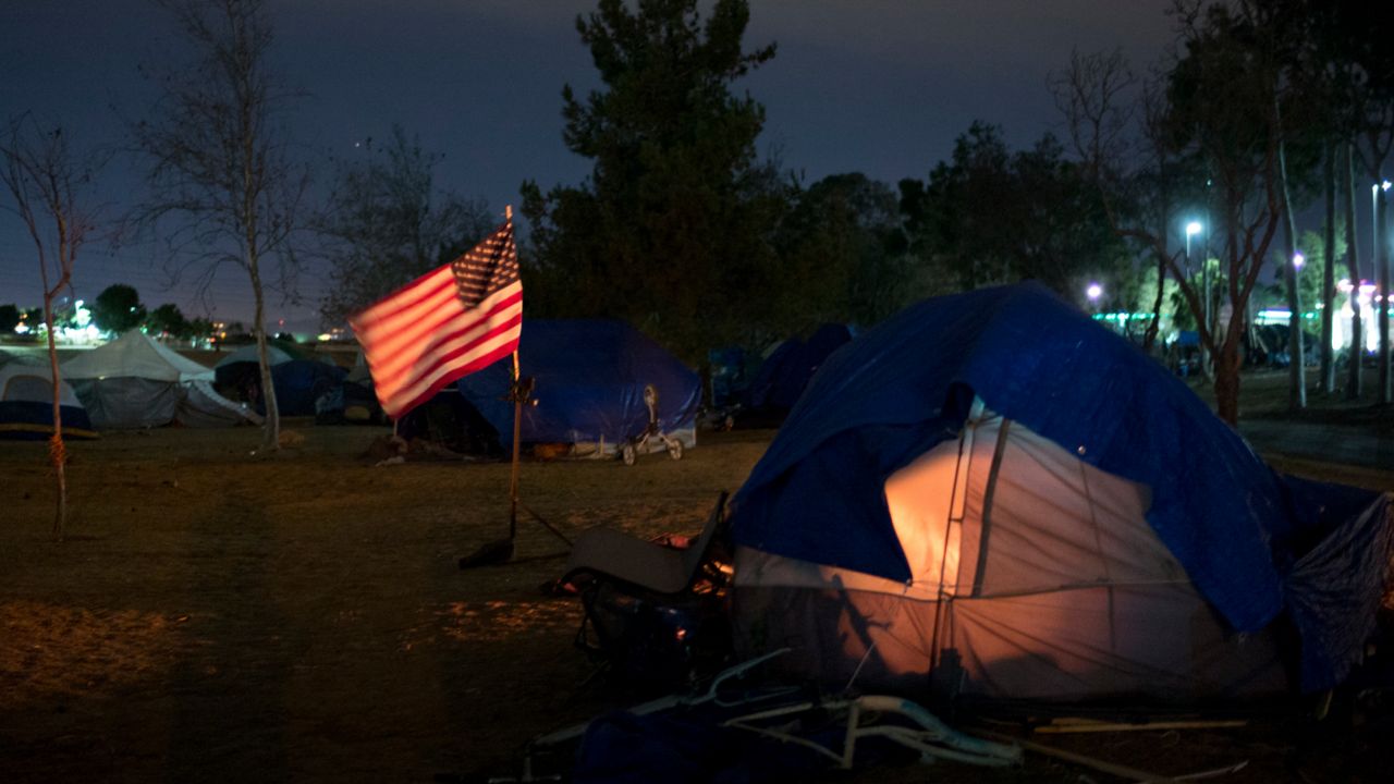 Homeless tents are pitched around an America flag along the Santa Ana River trail (AP/Jae C. Hong)