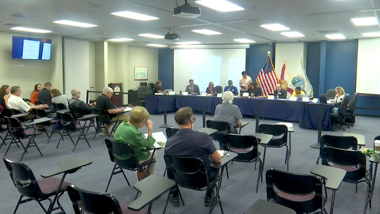 Members of the Orange County Canvassing Board go through ballots in the County Commission District 1 race Thursday. (Spectrum News)