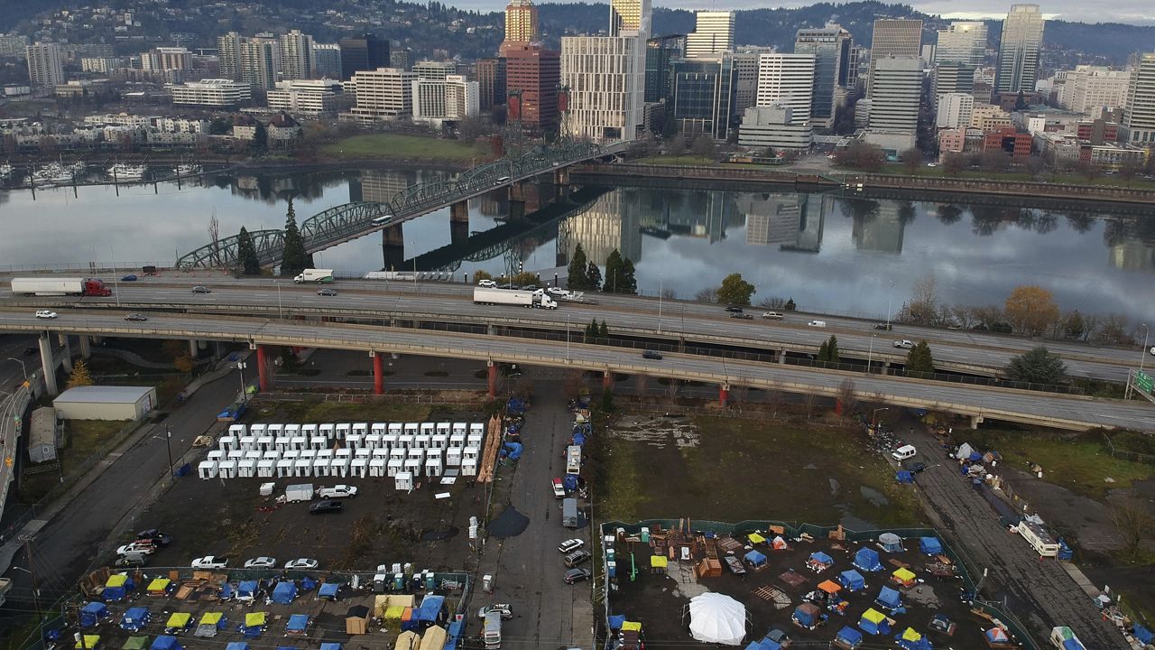 In this aerial photo tents housing people experiencing homelessness are set up on a vacant parking lot in Portland, Ore., on Dec. 8, 2020. (AP Photo/Craig Mitchelldyer)