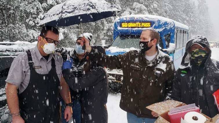 Health care workers administer a COVID-19 vaccination to a man during a snowstorm in southern Oregon on Tuesday. (Josephine County Public Health)