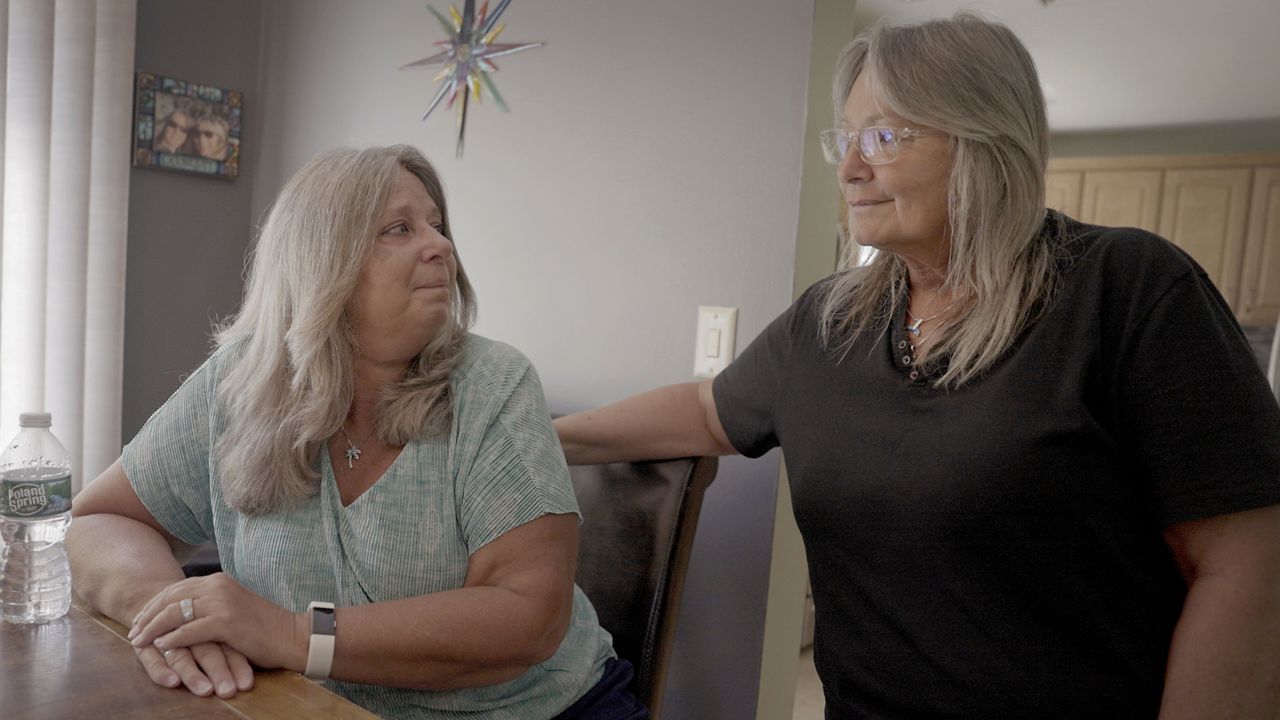 Mary Miller-Duffy sits next to her wife, Sue Duffy, in their home in Newburgh on Aug. 2, 2023.