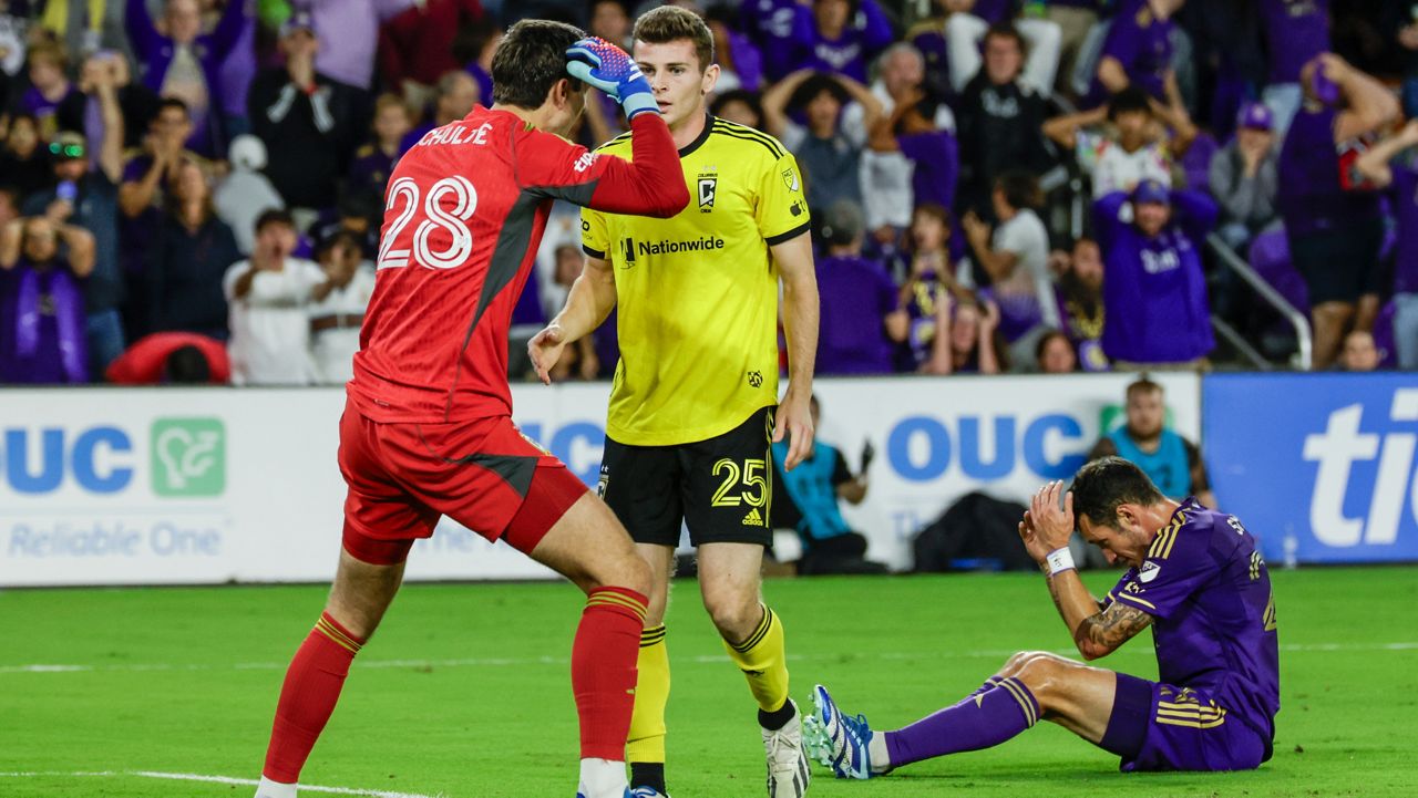 Orlando City defender Kyle Smith, right, reacts after miss a goal attempted and Columbus Crew goalkeeper Patrick Schulte (28) talks to team mate midfielder Sean Zawadzki (25) during ver time of an MLS soccer playoff match, Saturday, Nov. 25, 2023, in Orlando, Fla. (AP Photo/Kevin Kolczynski)