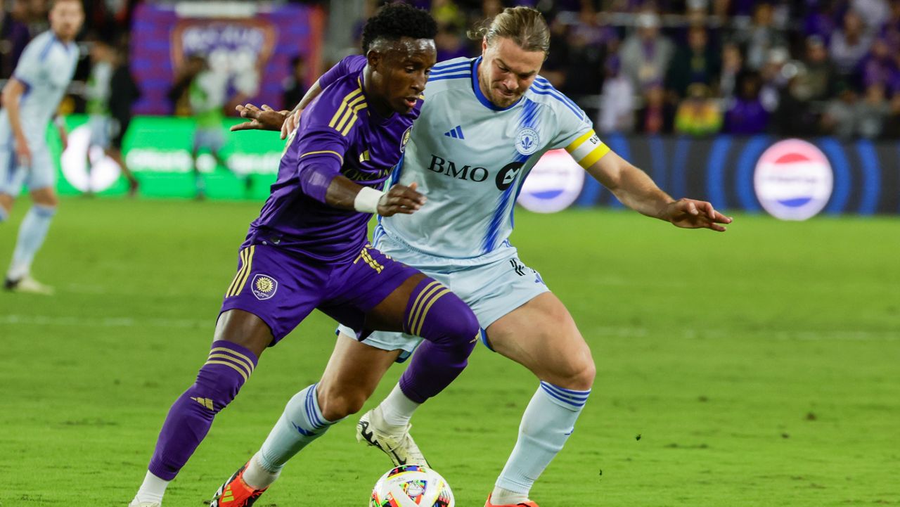 Orlando City forward Iván Angulo, left, is defended by CF Montréal midfielder Samuel Piette during the first half of an MLS soccer match Saturday, Feb. 24, 2024, in Orlando, Fla. (AP Photo/Kevin Kolczynski)