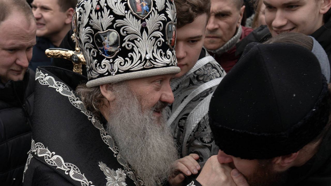 A senior priest of the Ukrainian Orthodox Church blesses parishioners in the Kyiv Pechersk Lavra monastery complex in Kyiv, Ukraine, Wednesday, March 29, 2023. The Russian invasion of Ukraine is reverberating in a struggle for control of a monastery complex. The government says it's evicting the Ukrainian Orthodox Church from the complex as of March 29, accusing it of pro-Russia actions and ideology. (AP Photo/Andrew Kravchenko)