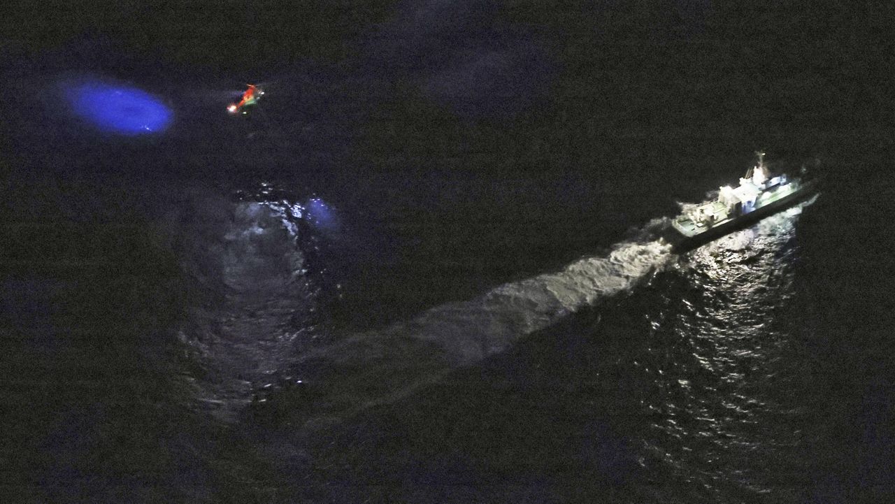 A Japanese coast guard vessel and a helicopter conduct search-and-rescue operation around the site where a U.S. military Osprey aircraft was believed to crash in the sea off Yakushima Island, Kagoshima prefecture, southern Japan Wednesday, Nov. 29, 2023. (Kyodo News via AP)