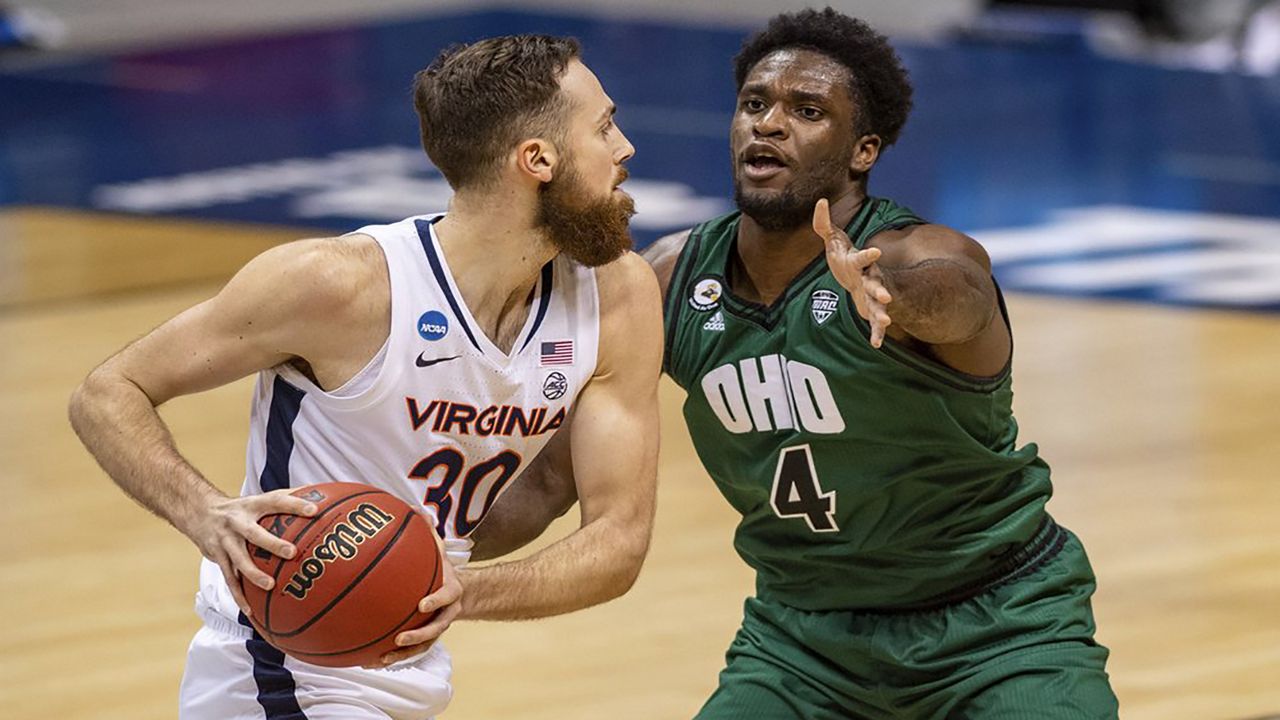 Ohio forward Dwight Wilson III (4) defends against Virginia forward Jay Huff (30) during the first half of a first-round game in the NCAA men's college basketball tournament, Saturday, March 20, 2021, at Assembly Hall in Bloomington, Ind. (AP Photo/Doug McSchooler)