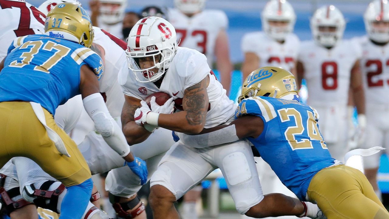 Stanford running back Austin Jones (20) is tackled by UCLA defensive back Qwuantrezz Knight (24) during the first half of an NCAA college football game Saturday, Dec. 19, 2020, in Pasadena, Calif. (AP Photo/Ringo H.W. Chiu)