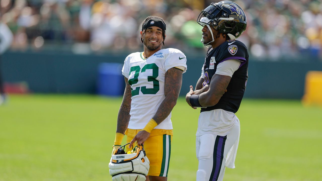 Green Bay Packers cornerback Jaire Alexander (23) and Baltimore Ravens quarterback Lamar Jackson (8) share a laugh during an NFL football joint training camp practice Thursday, Aug. 22, 2024, in Green Bay, Wis. (AP Photo/Matt Ludtke)