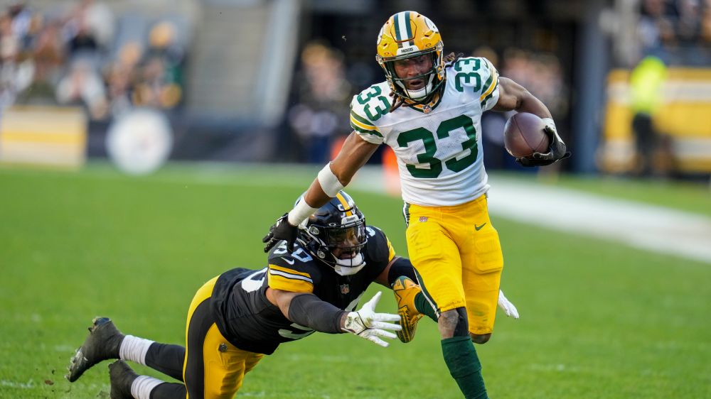 Green Bay Packers' Aaron Jones is stopped by Pittsburgh Steelers' Elandon Roberts during the second half of an NFL football game