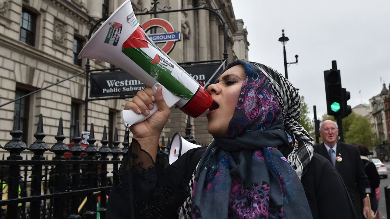 Pro-Palestinian protester holds a megaphone ahead of a march in support of the Palestinian people in Gaza, in London, Saturday, April 27, 2024. (AP Photo/Thomas Krych)