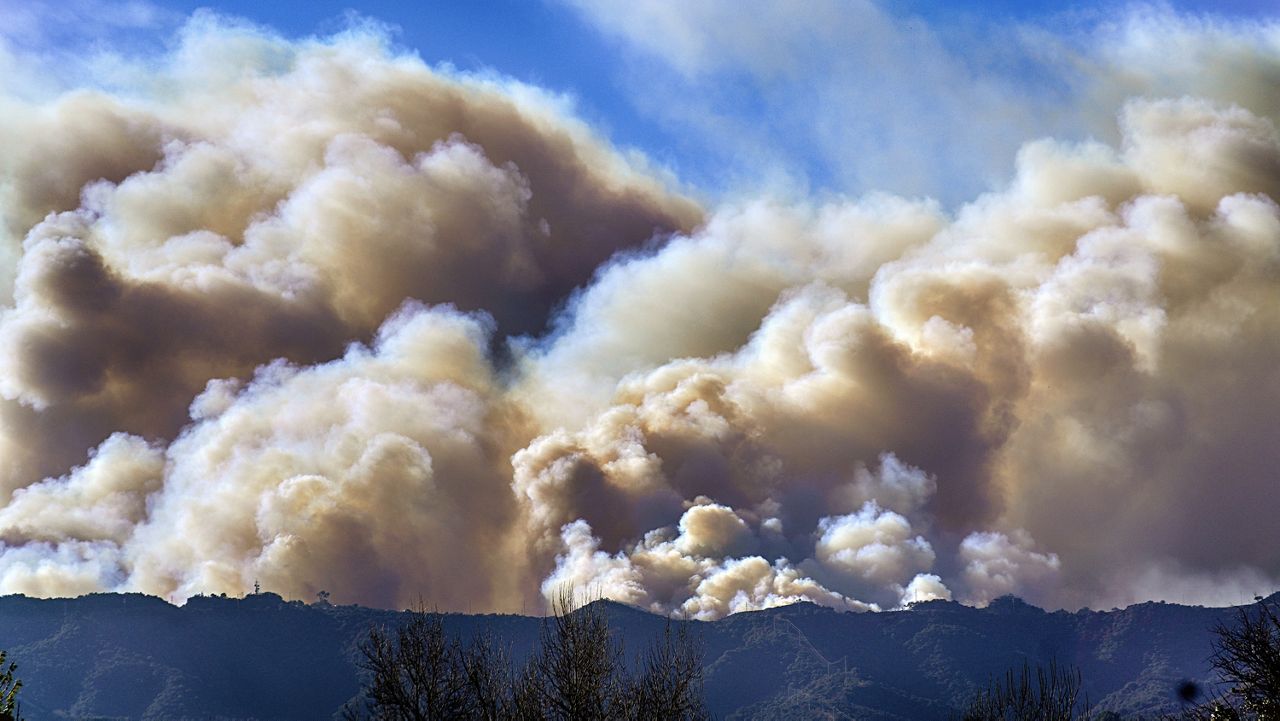 Smoke from the Palisades Fire rises over a ridge as seen from the Encino section of Los Angeles on Saturday, Jan. 11, 2025. (AP Photo/Richard Vogel)