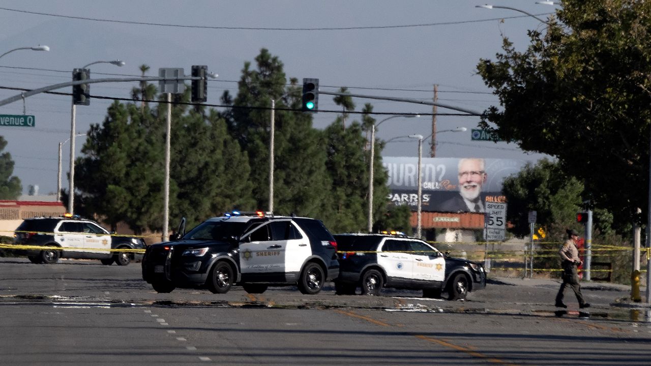 Police cars block off a street where a sheriff's deputy was shot while in his patrol car in Palmdale, Calif. on Sunday, Sept. 17, 2023. (AP Photo/Richard Vogel)