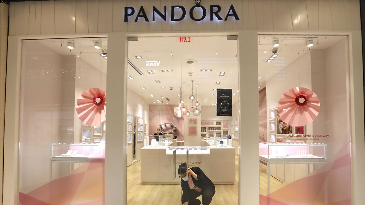 Tania Lima unlocks the glass doors opening a Pandora retail store in the Galleria Dallas mall in Dallas. (AP Photo/LM Otero)