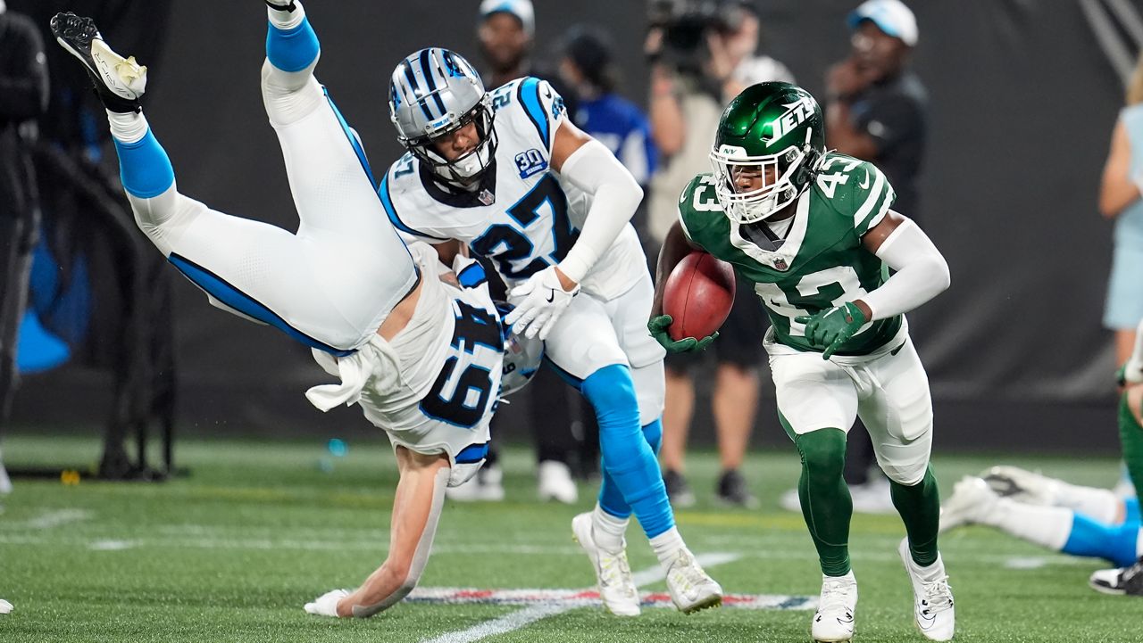 New York Jets' Brandon Codrington (43) returns a punt against Carolina Panthers' Feleipe Franks (49) and Alex Cook (27) during a preseason NFL football game Saturday, Aug. 17, 2024, in Charlotte, N.C. (AP Photo/Mike Stewart)