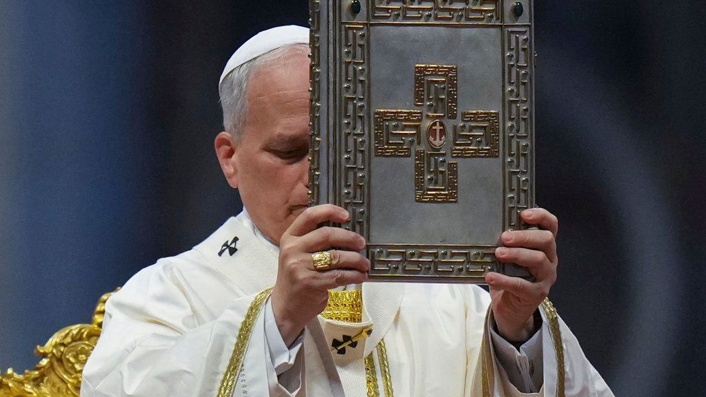 El papa León XIV alza el Evangelio en la Basílica de San Pedro el domingo 15 de junio de 2025.