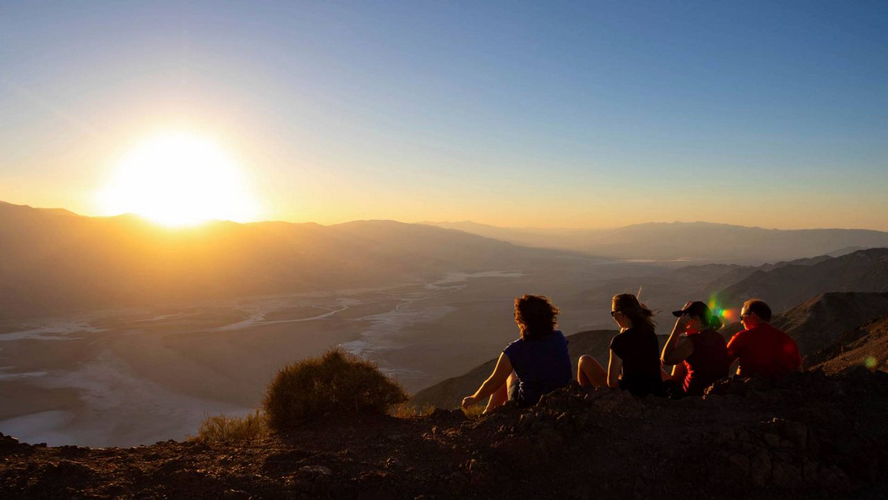 Park visitors watch the sunset on Tuesday in Death Valley National Park, Calif. July is the hottest month at the park with an average high of 116 degrees. (AP Photo/Ty ONeil)