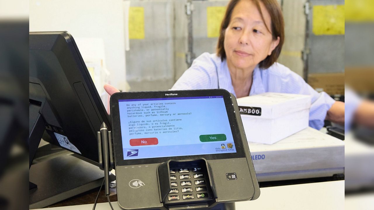 Post office employees like Faye Ono (pictured) are trained to ask customers whether their package contains potentially hazardous materials such as explosives. Customers who lie have little to fear. (Honolulu Civil Beat/David Croxford)