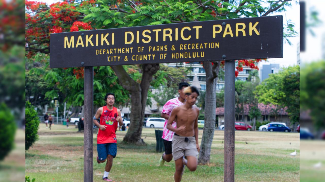 The runners start each practice with a two lap warmup, crossing into the route some of the dog walkers take. (Honolulu Civil Beat/Leilani Combs)