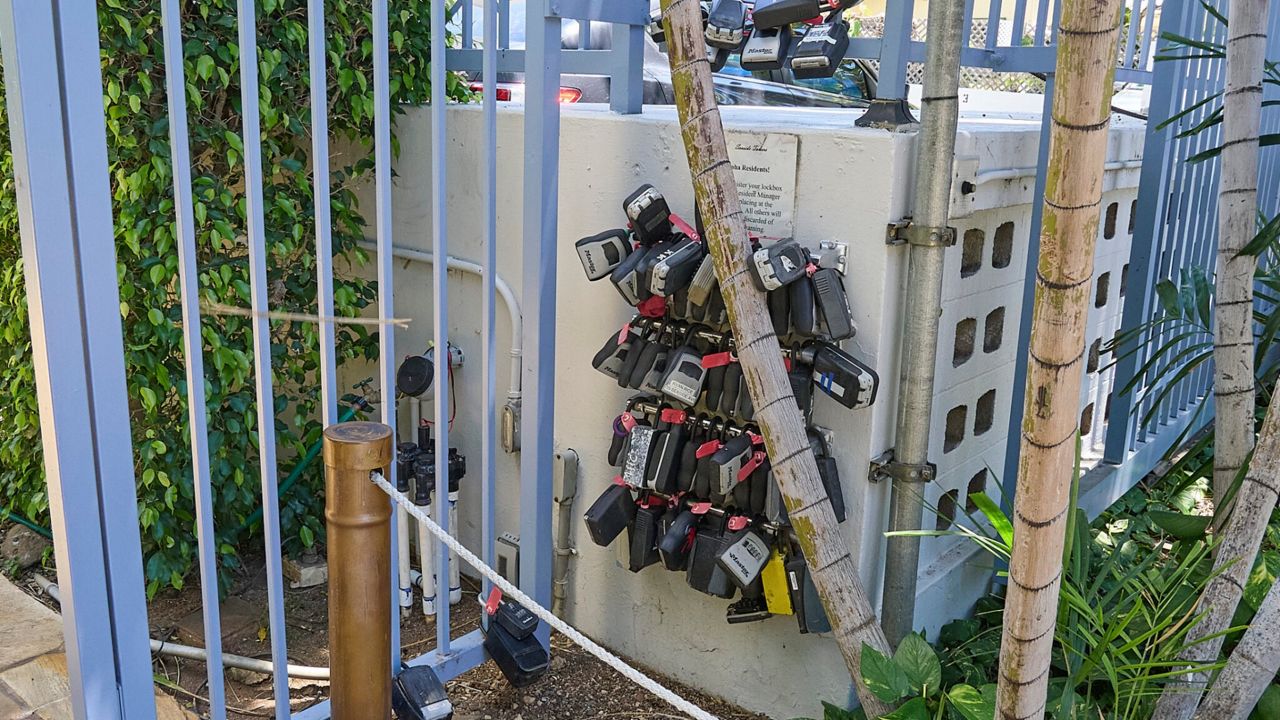 Lockboxes hang ready for vacationers arriving at the main pedestrian gate of a condominium building in Waikīkī. (Honolulu Civil Beat/David Croxford)