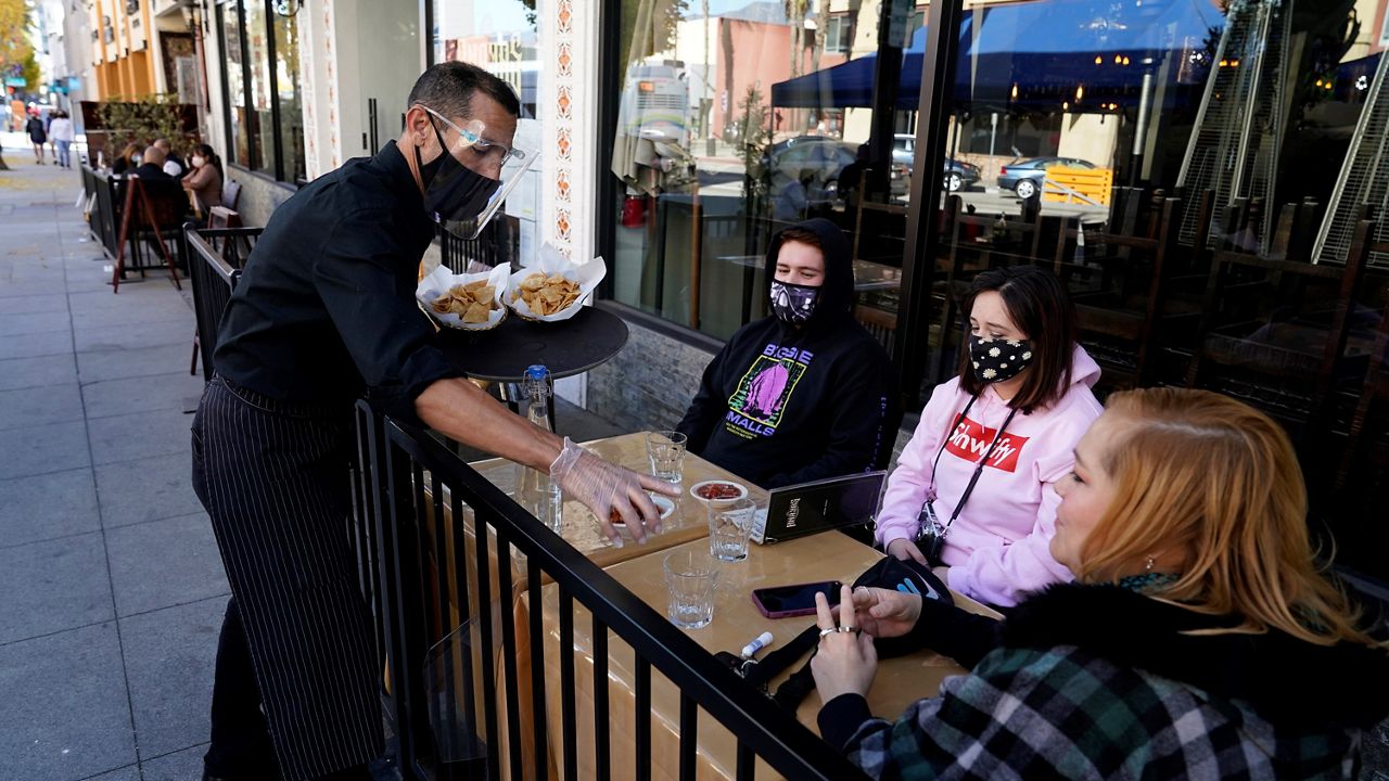 In this Dec. 1, 2020, file photo, customers are served lunch at an outdoor seating space in Pasadena, Calif. (AP Photo/Marcio Jose Sanchez)