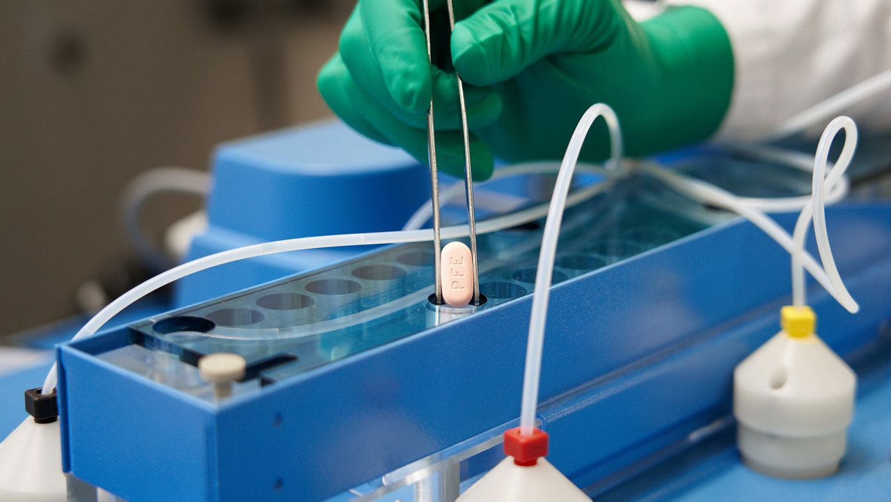 A Pfizer technician handles one of the company's COVID-19 Paxlovid antiviral pills. (Pfizer via AP, file)