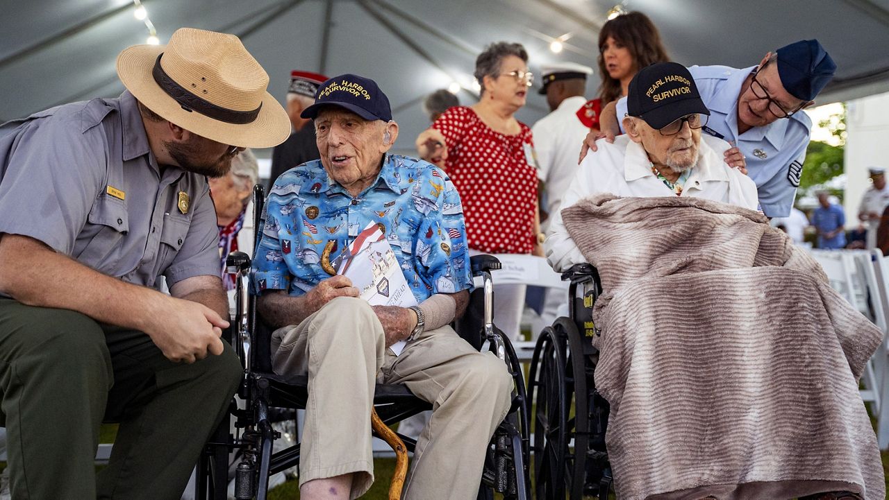 Pearl Harbor survivors, Ken Stevens, 102, of Powers, Ore., second from the left, and Ira "Ike" Schab, 104, of Beaverton, Ore., wait before the start of the 83rd Pearl Harbor Remembrance Day ceremony, Saturday, Dec. 7, 2024, in Honolulu. (AP Photo/Mengshin Lin)