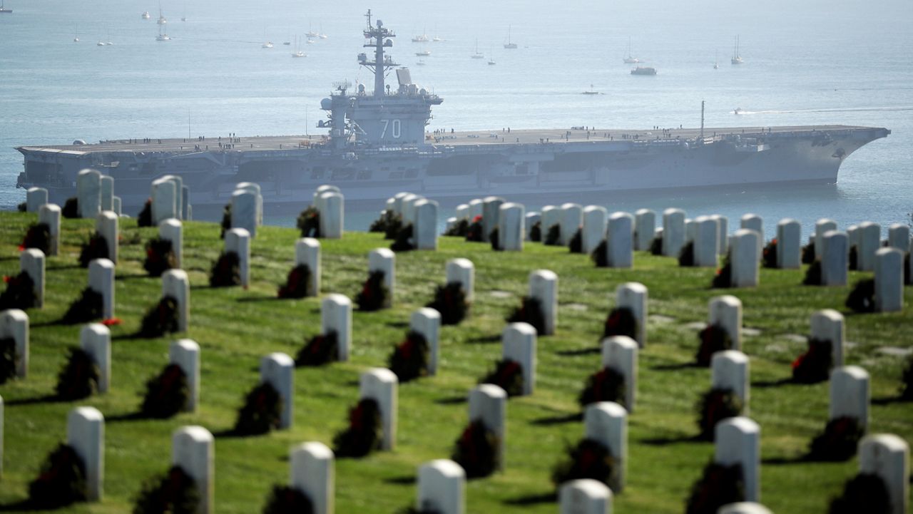 The nuclear-powered USS Carl Vinson aircraft carrier passes Fort Rosecrans National Military Cemetery as it leaves San Diego Bay for deployment to the western Pacific Friday, Jan. 5, 2018, in San Diego. (AP Photo/Gregory Bull)