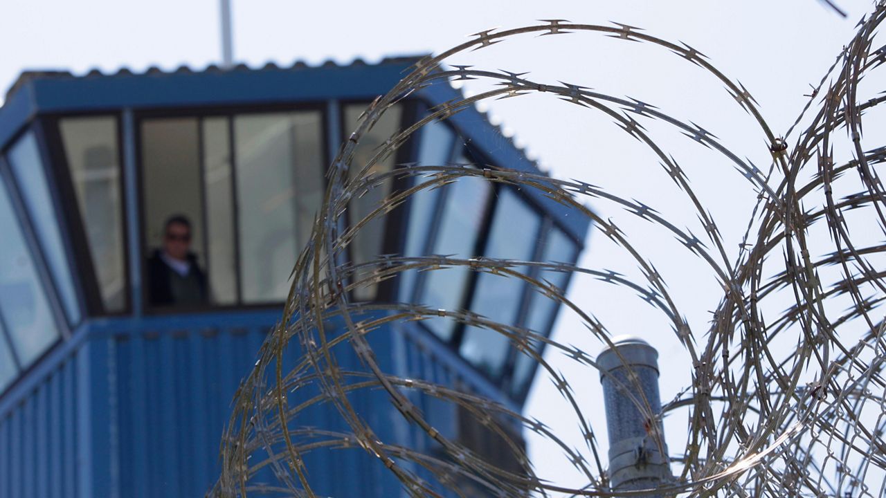 In this Aug. 17, 2011, file photo, concertina wire and a guard tower are seen at Pelican Bay State Prison near Crescent City, Calif. (AP Photo/Rich Pedroncelli, File)