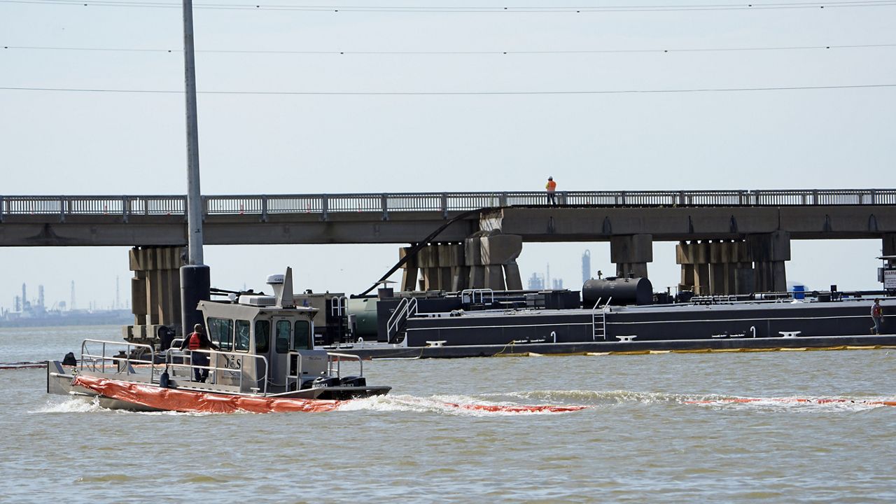 A spill boom is moved into position to contain a leak from a barge that crashed into the Pelican Island Bridge, Wednesday, May 15, 2024, in Galveston, Texas. (AP Photo/David J. Phillip)