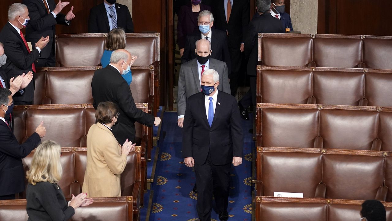 Vice President Mike Pence arrives with members of the Senate to officiate as a joint session of the House and Senate convenes to count the electoral votes cast in November's election. (AP Photo/Andrew Harnik)