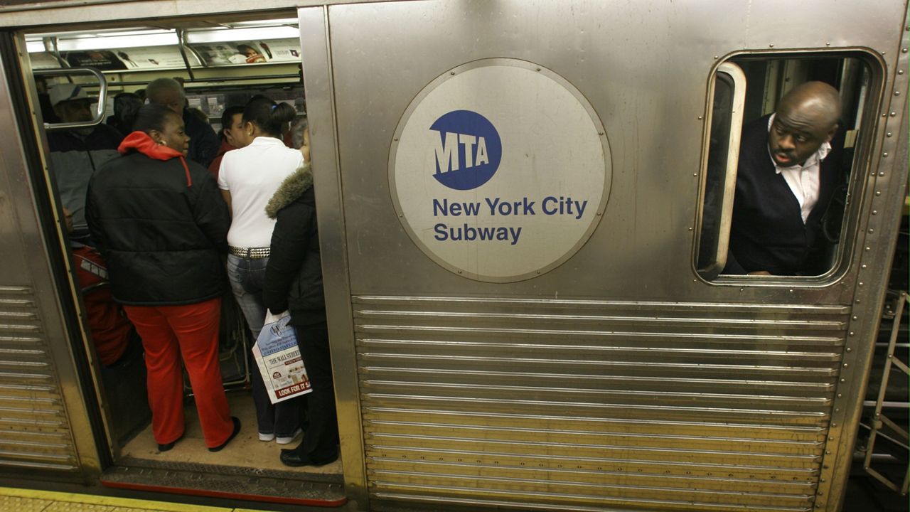 A subway conductor makes a final check on passengers boarding his train in New York on Friday Jan. 20, 2006.