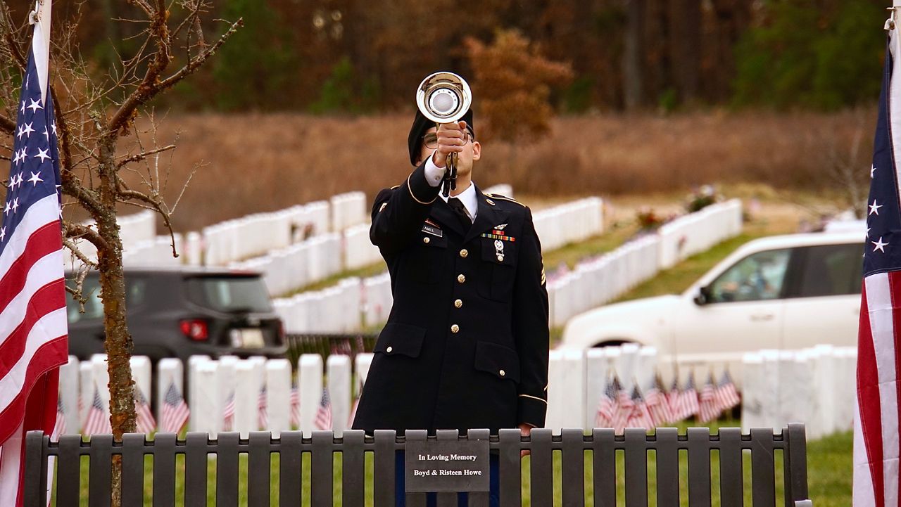 A solider plays Taps ahead of the service for Pfc. Charles Wells (Spectrum News 1/Mason Brighton)